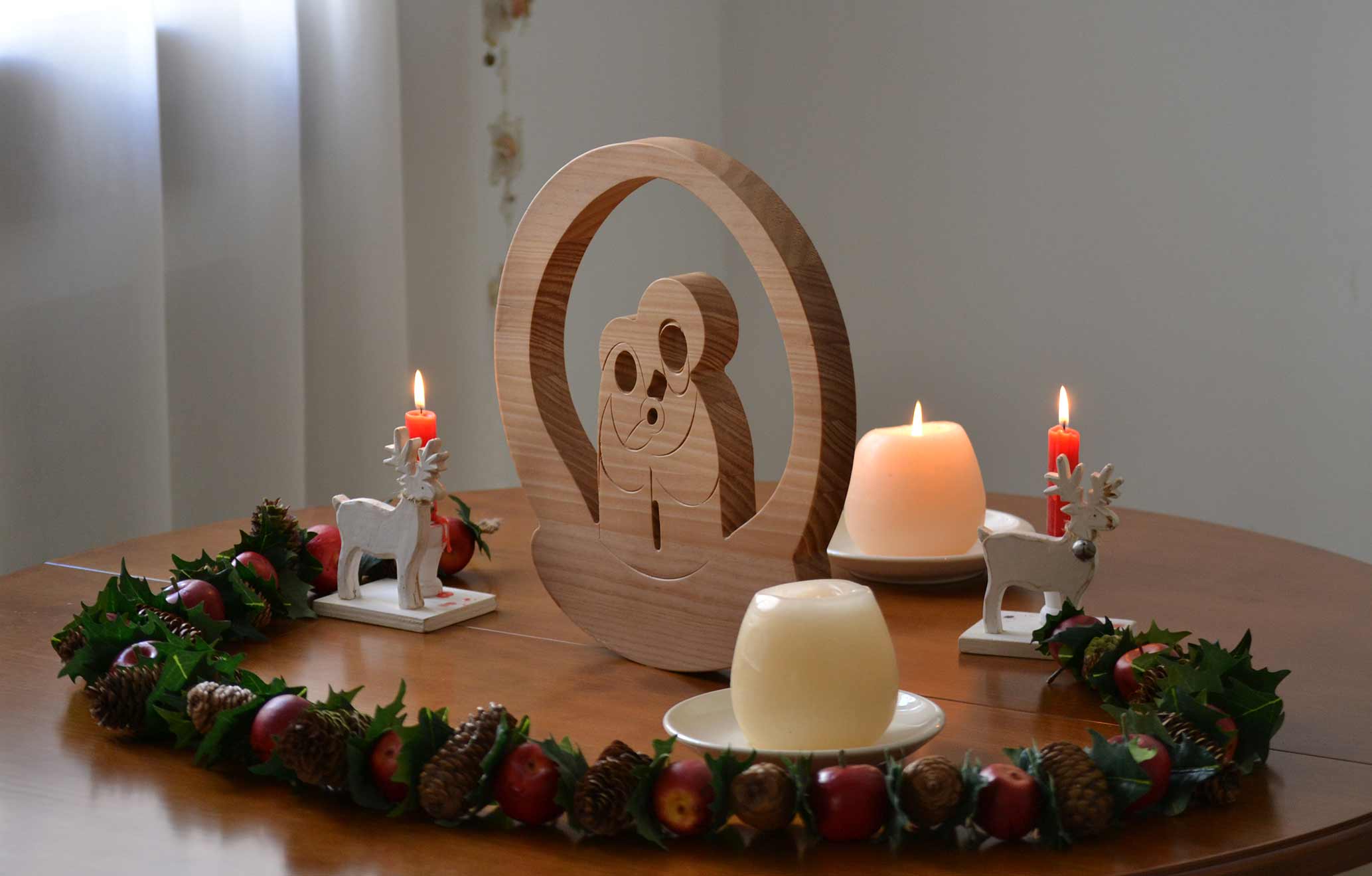 Centro de mesa navideño, con belén de madera, velas y floral navideño