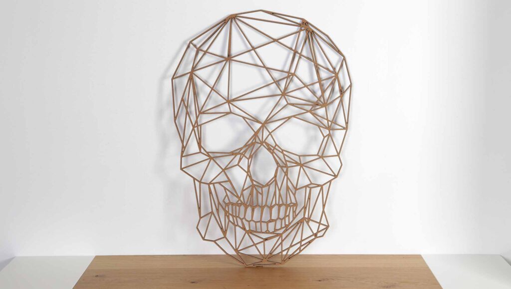 decoración con figuras geométricas de madera. Fotografía de calavera de madera decorativa con diseño geométrico sobre una mesa.