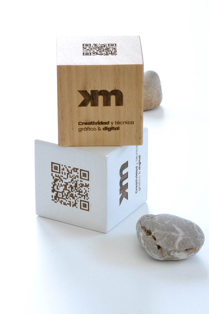 dos prismas con QR grabados en madera con piedras decorativas. Estética y funcionalidad