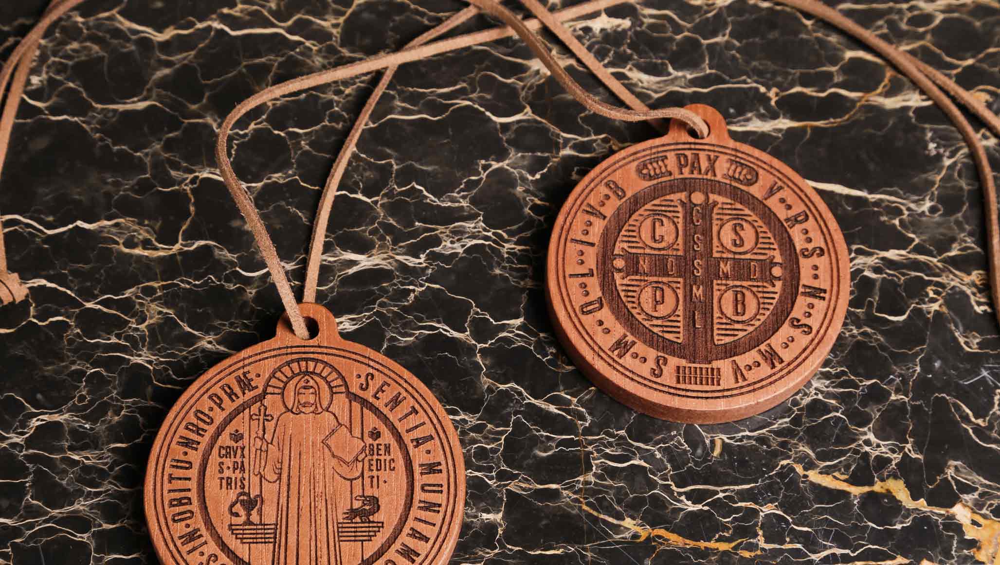 Anverso y reverso de Medalla de san Benito de madera realizada en madera de cedro con cordón de cuero de la marca hecco
