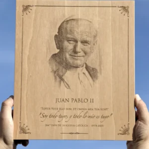 Grabado en madera de la imagen de Juan Pablo II sujetado con las manos y el cielo de fondo